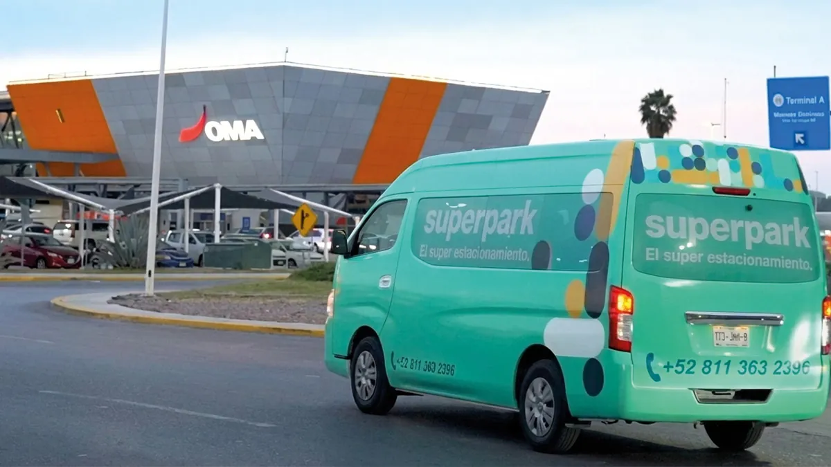 Camioneta de traslado gratuito de SuperPark circulando frente a la Terminal A del Aeropuerto Internacional de Monterrey (OMA).